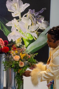 a woman is putting flowers in a vase